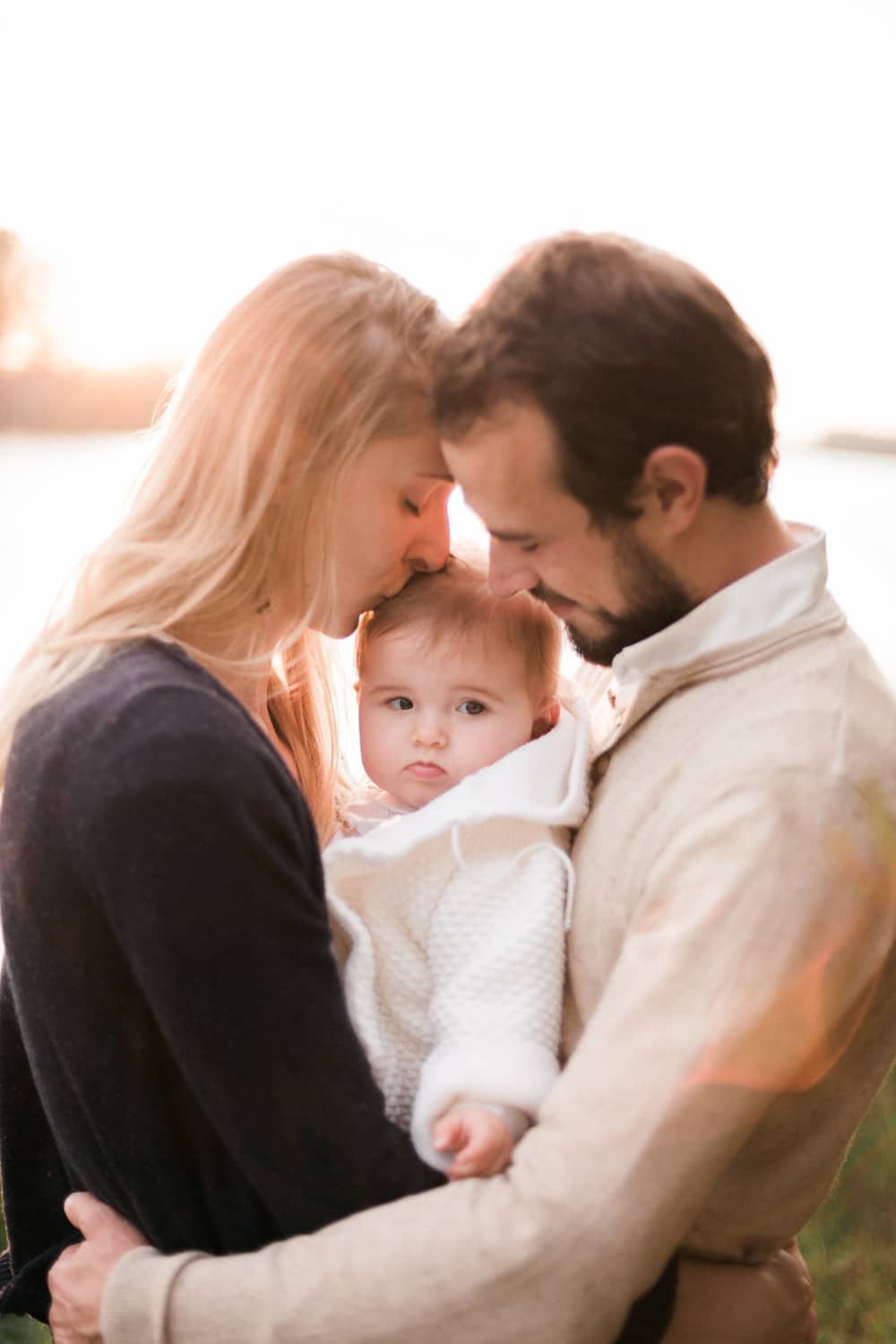 photographe de famille : portrait de famille, lors d'un câlin avec la maman, le papa, et leur fille, photo lumineuse au bord de garonne, séance photo automne