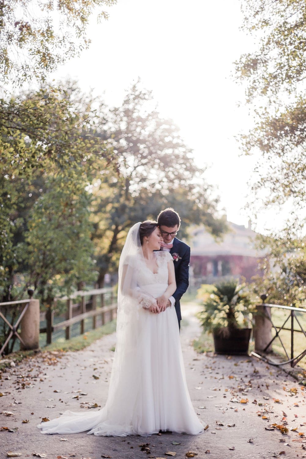 photographe fine art mariage : couple de mariés tendrement enlacés et amoureux sur une photo lumineuse en contre-jour