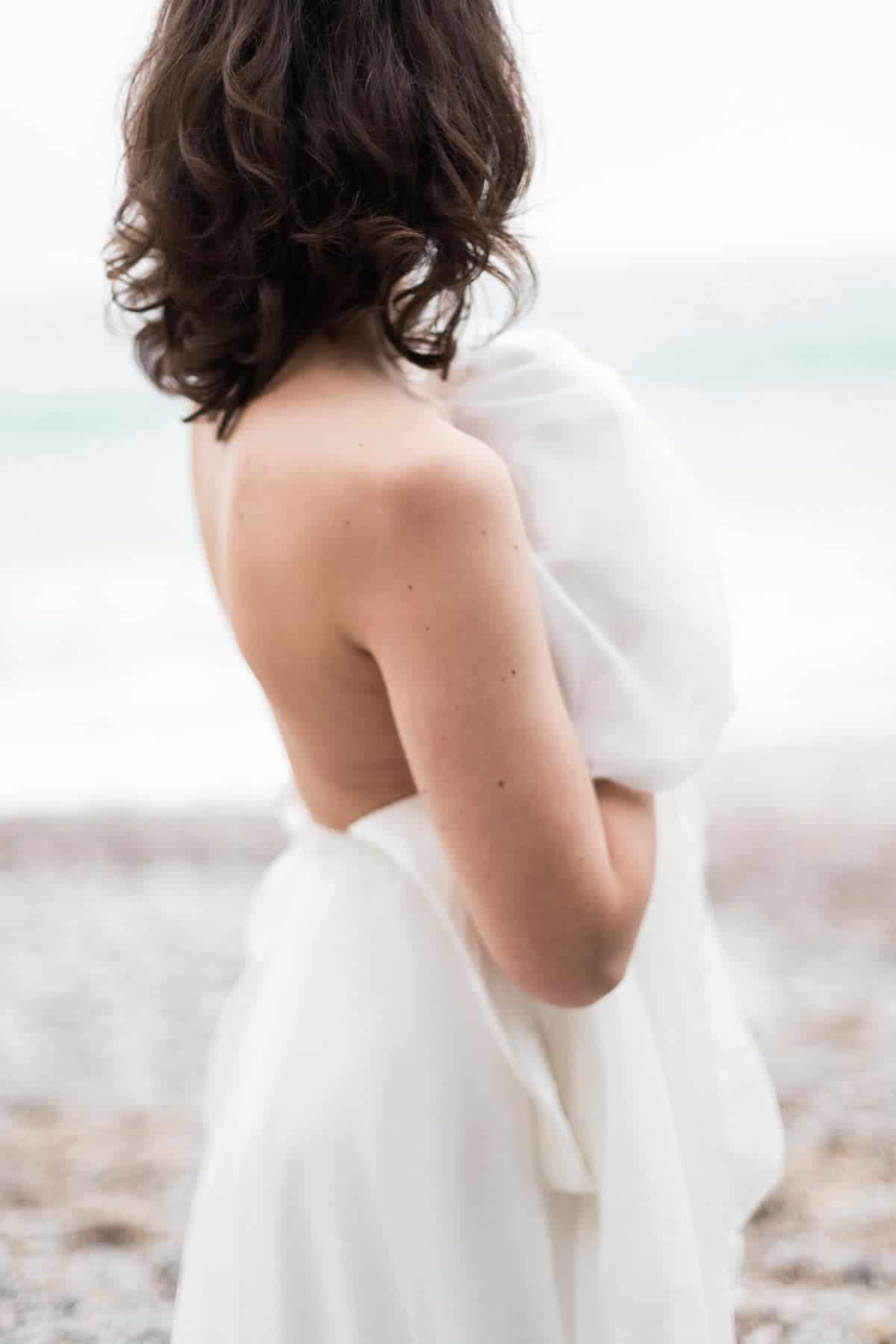 Mariée de dos, sensuelle et romantique, sur la plage d'Etretat