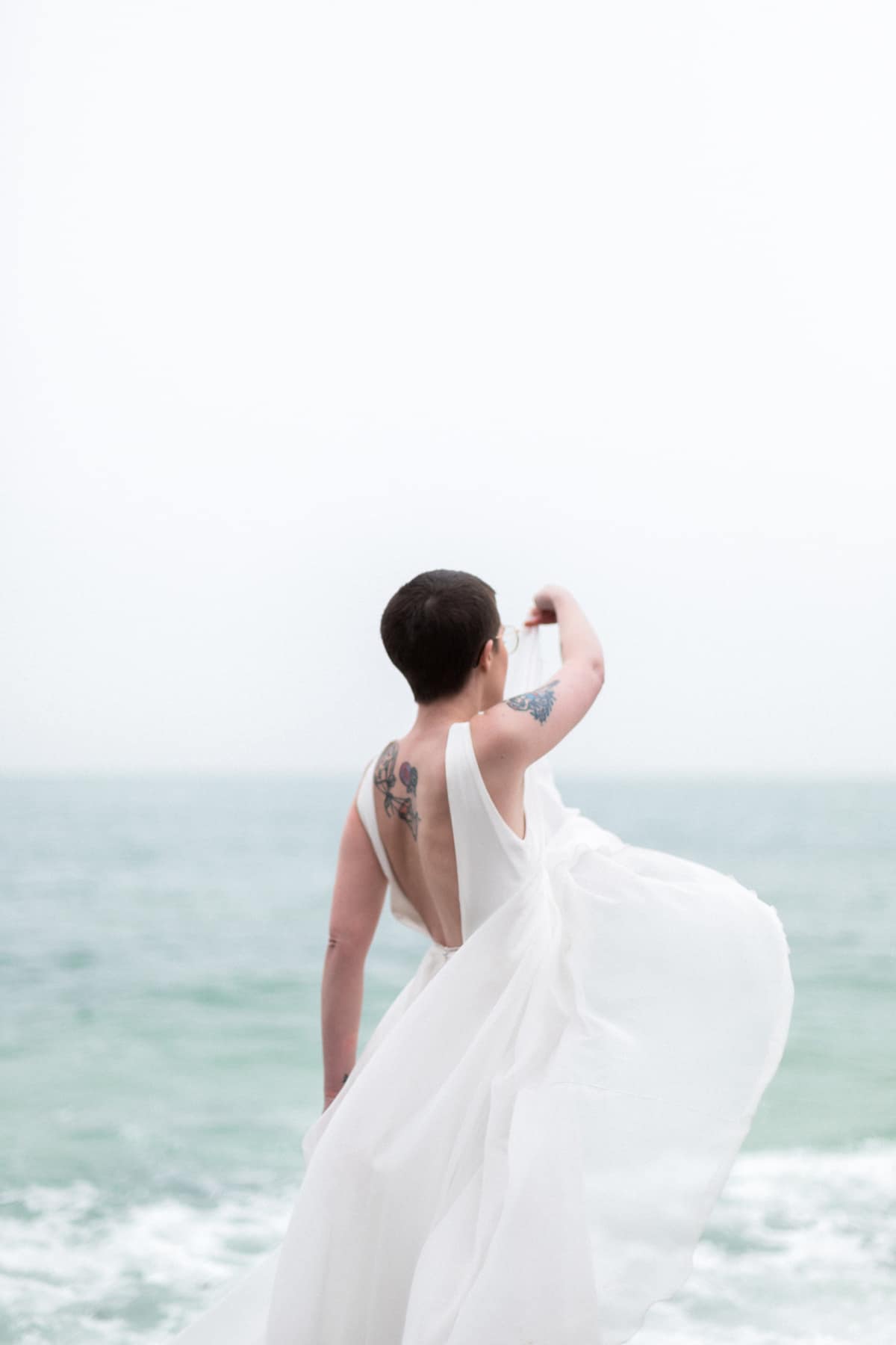 Photographe de mariage sur la plage : la mariée danse avec sa robe