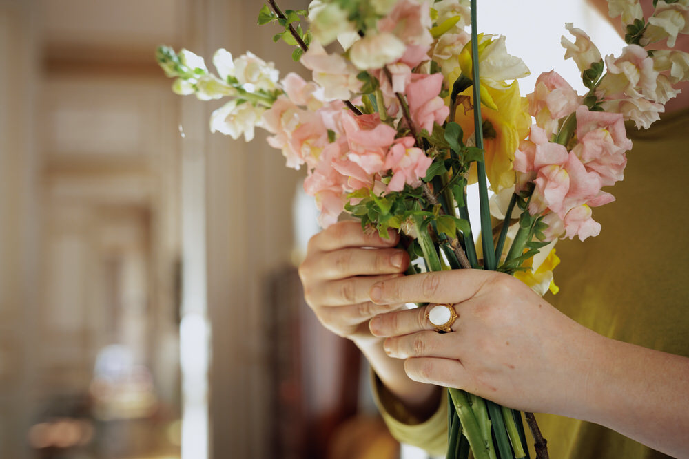 gros plan sur les mains d'une fleuriste composant un bouquet de fleurs de printemps